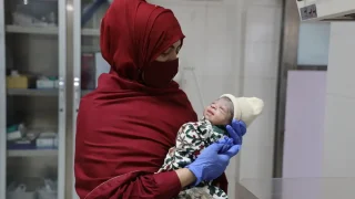 Razia Bibi sostiene a un bebé recién nacido en la maternidad de MSF en Chaman, Pakistán