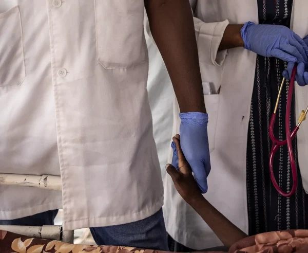 Una enfermera sostiene la mano de Haidara Atim, de 10 años, que sufría de bronquitis traqueal y shock séptico, después de que muriera cuando los médicos no pudieron resucitarlo en la unidad de cuidados intensivos del Hospital MSF en Metche, en el este de Chad, el 7 de agosto de 2024.