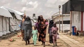 Mujeres y niños caminan por el hospital de Médicos Sin Fronteras en Metche, Chad, tras huir de la guerra en Sudán. 7 de agosto de 2024.