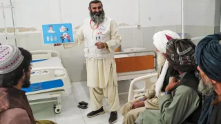 Haji Abdul Rehman Niamatullah, promotor de salud de MSF explica a un grupo de pacientes cómo prevenir infecciones y la importancia de tomar correctamente los antibióticos que les receta el médico.