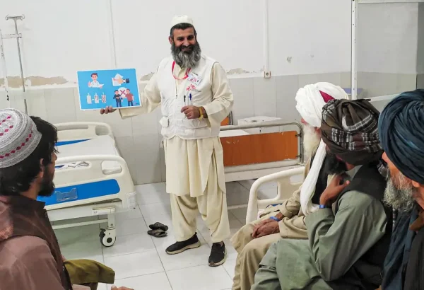 Haji Abdul Rehman Niamatullah, promotor de salud de MSF explica a un grupo de pacientes cómo prevenir infecciones y la importancia de tomar correctamente los antibióticos que les receta el médico.