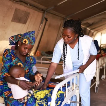 Personal de MSF toma los signos vitales de Nura, la hija de Zainab, en el centro de alimentación terapéutica para pacientes hospitalizados con desnutrición aguda, Nigeria.