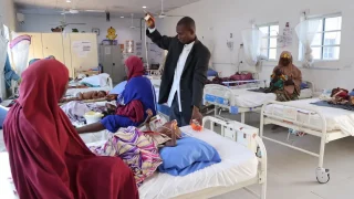 Un enfermero de MSF se prepara para tomar los signos vitales de un niño en cuidados intensivos de Ungwa Uku, en donde MSF trata la desnutrición infantil en Kano, Nigeria.