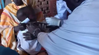 Personal de MSF administra una vacuna contra el sarampión a un niño en Rokero, Sudán.