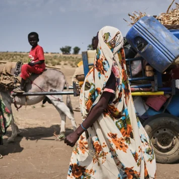 Una familia recién llegada a Jerbana, cerca de la frontera con Sudán, llega con todas sus pertenencias en una carreta tirada por burros. Este es el medio de transporte que utilizan la mayoría de los refugiados que cruzan a Sudán del Sur. Jerbana, Sudán del Sur, febrero de 2025.