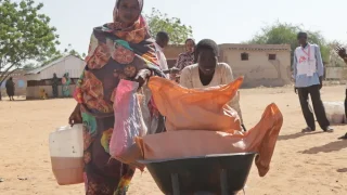 Una madre y su hijo reciben una canasta de alimentos en el campo de personas internamente desplazadas de Autash. Sudán.