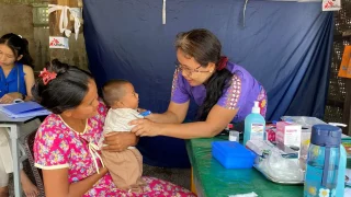 Una integrante de MSF revisando a un bebé en una clínica movil de la organización en Mandalay, donde respondió tras el terremoto en Myanmar.