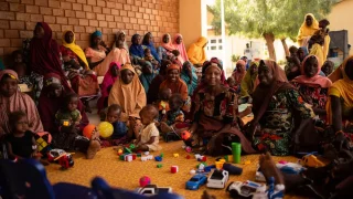 Mujeres, niñas y niños asisten a las sesiones sobre la promoción de la salud nutricional en el centro de alimentación para pacientes hospitalizados de la ciudad de Katsina, Nigeria.