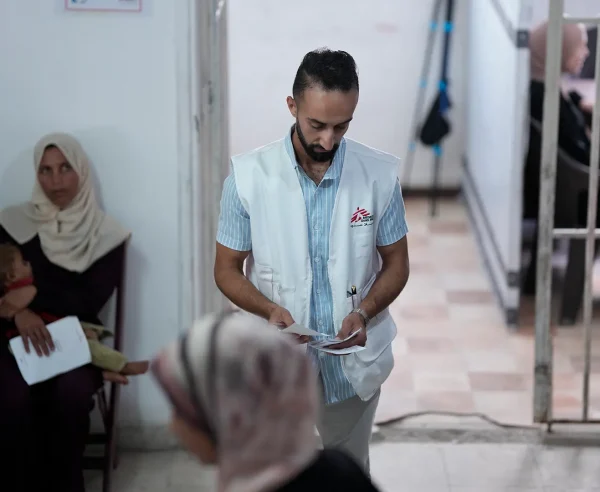 Un miembro del personal de MSF organiza a los pacientes para que vean al personal médico en la clínica de MSF en la ciudad de Gaza, en el norte de Gaza, Palestina, junio de 2025.