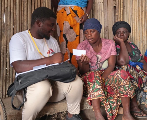 Issa Manzi Makaburi, promotor de MSF, apoyando a una mujer en el campo de personas desplazadas de Mueda
