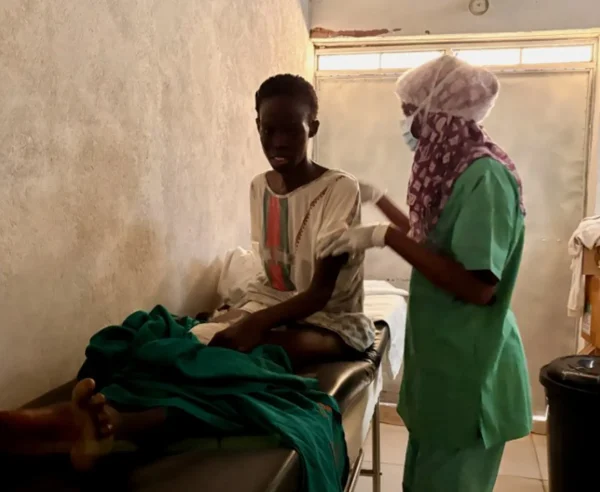 Una enfermera prepara a joven para la cirugía de las heridas infectadas por disparos y metralla que sufrió hace seis meses y que fueron operadas inicialmente en El Fasher. Imagen tomada el pasado 11 de octubre en el hospital de MSF en Tawila.