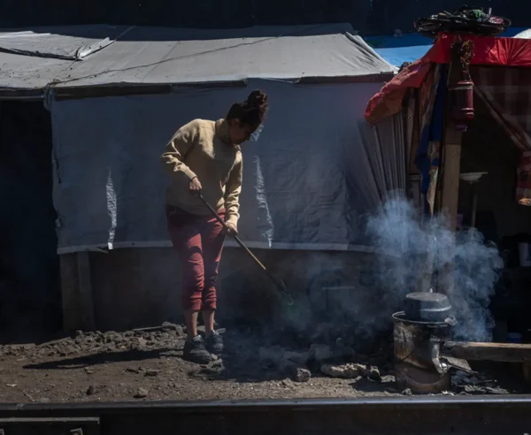 Carmen limpia el exterior de su “ranchito” en el barrio de Vallejo, el lugar que ha sido su hogar durante los últimos meses luego de que ya no pudiera continuar su viaje a Estados Unidos en busca de una vida con más oportunidades y seguridad para ella y su familia.