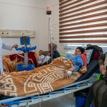 Una enfermera del Hospital Nacional de Nawa atiende a una madre que dio a luz en la sala de maternidad, donde MSF garantiza atención médica integral y seguimiento a las madres y sus hijos.