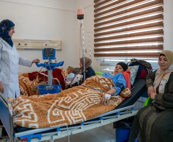 Una enfermera del Hospital Nacional de Nawa atiende a una madre que dio a luz en la sala de maternidad, donde MSF garantiza atención médica integral y seguimiento a las madres y sus hijos.