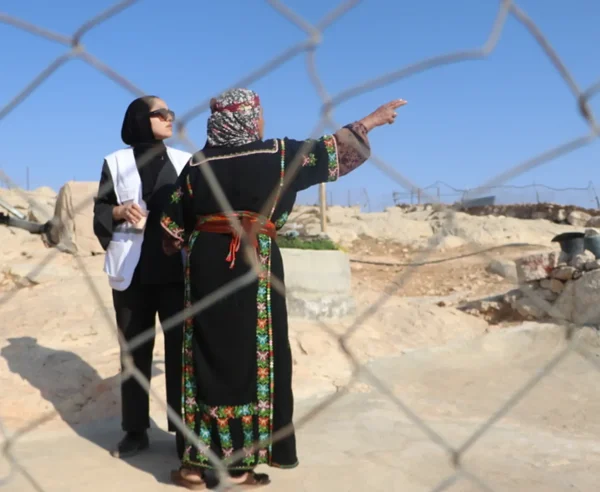 Un trabajador social de MSF conversa con Sabha Al Najar, quien, junto con su esposo, Mahomud, fue atacado y golpeado por colonos a principios de noviembre de 2025 en su hogar en Shi'b al-Butum, al sur de Hebrón. Cisjordania, Palestina.