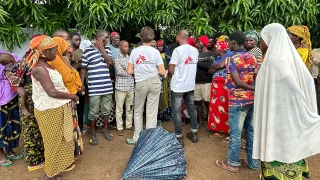 El equipo de MSF conversa con un grupo de personas desplazadas que esperan fuera de una clínica móvil de MSF en Alua Velha, provincia de Nampula, Mozambique.