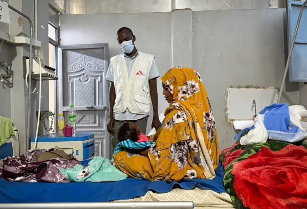 Ferdos Salih sostiene a su bebé de 11 meses, Banan, quien padece sarampión, en la sala de aislamiento del Hospital Universitario El Geneina, con apoyo de MSF. Sudán, diciembre de 2025.