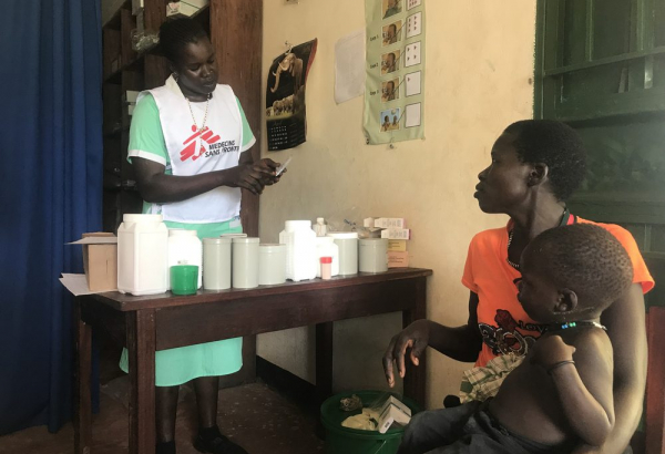 La enfermera de MSF Abau Susan entrega la medicación a una madre y le explica cómo y cuándo debe dársela a su hijo en el Centro de Atención Primaria del Ministerio de Salud en Kediba, Sudán del Sur.