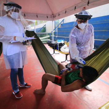 Health team takes the temperature of an indigenous Warao man in an isolation and observation center for people with mild cases of COVID-19