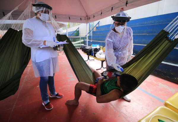 Health team takes the temperature of an indigenous Warao man in an isolation and observation center for people with mild cases of COVID-19
