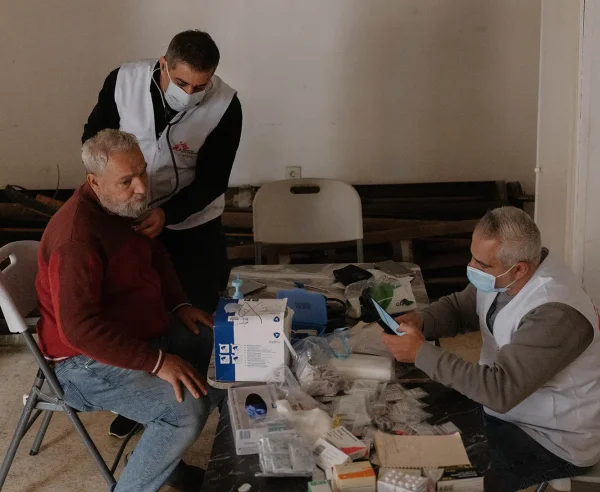 Un médico de MSF revisa el pecho de un hombre desplazado mientras un enfermero registra sus constantes vitales. Líbano, Beirut, 2026.