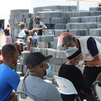 Un integrante de MSF atendiendo a un grupo de pesonas migrantes
