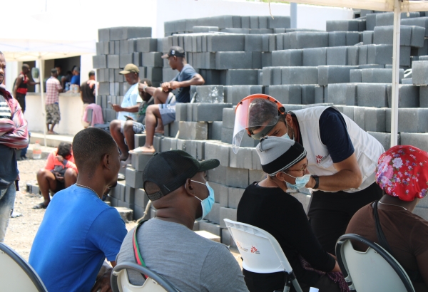 Un integrante de MSF atendiendo a un grupo de pesonas migrantes